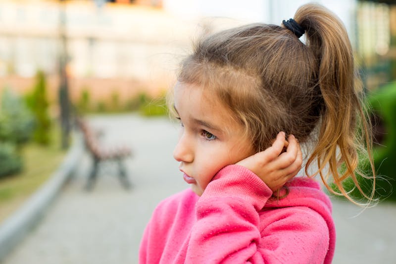 Child holding her ear
