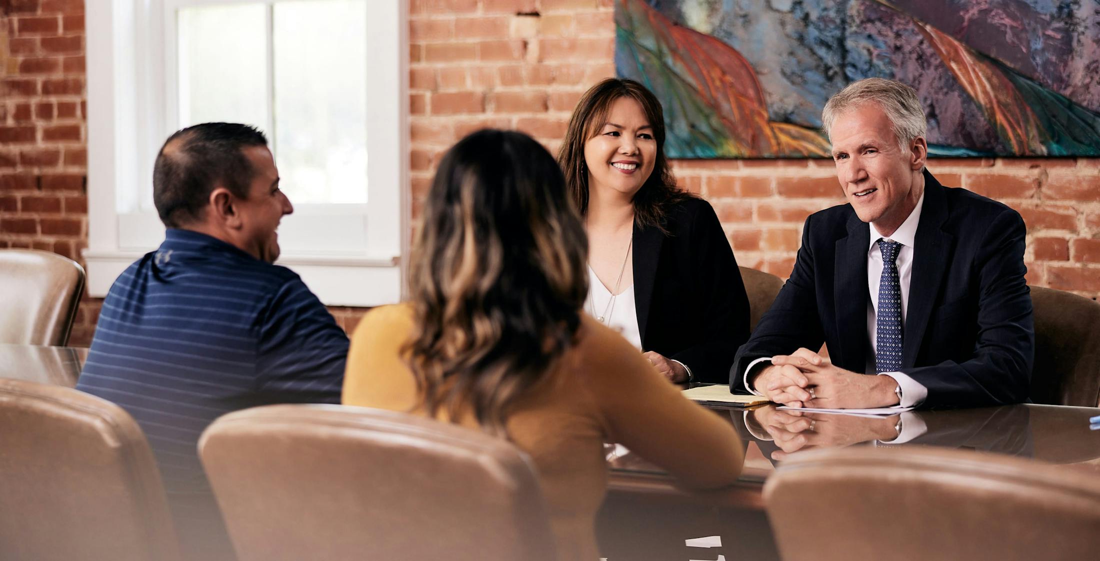 Sean Lyons and LoAn Vo at a table talking with clients.