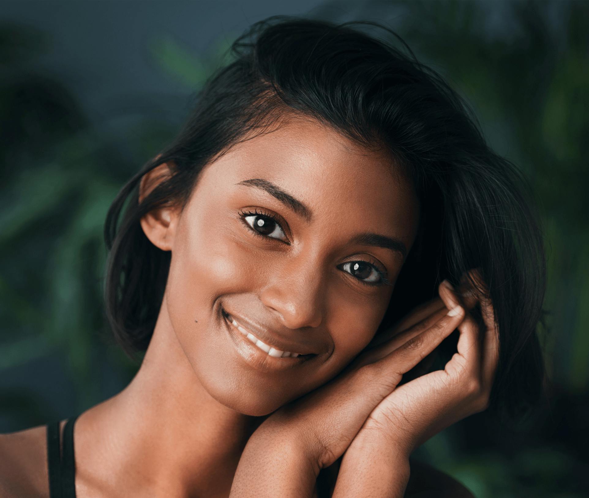 smiling woman leaning her head on her hands