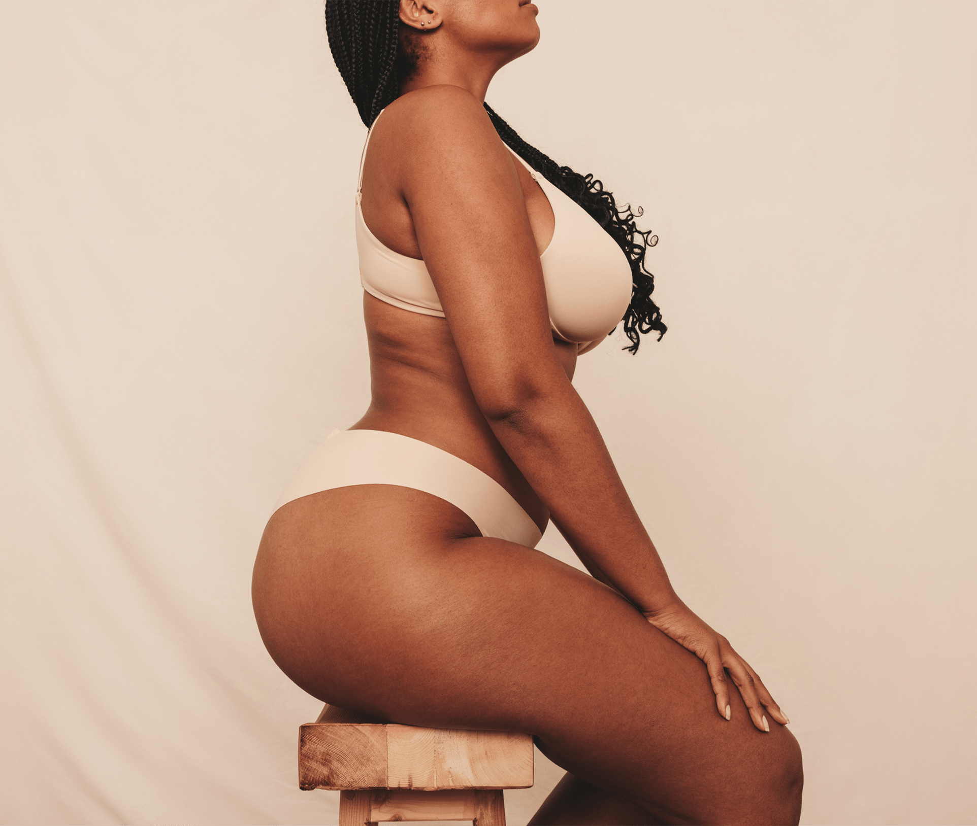 woman in underwear sitting on a stool