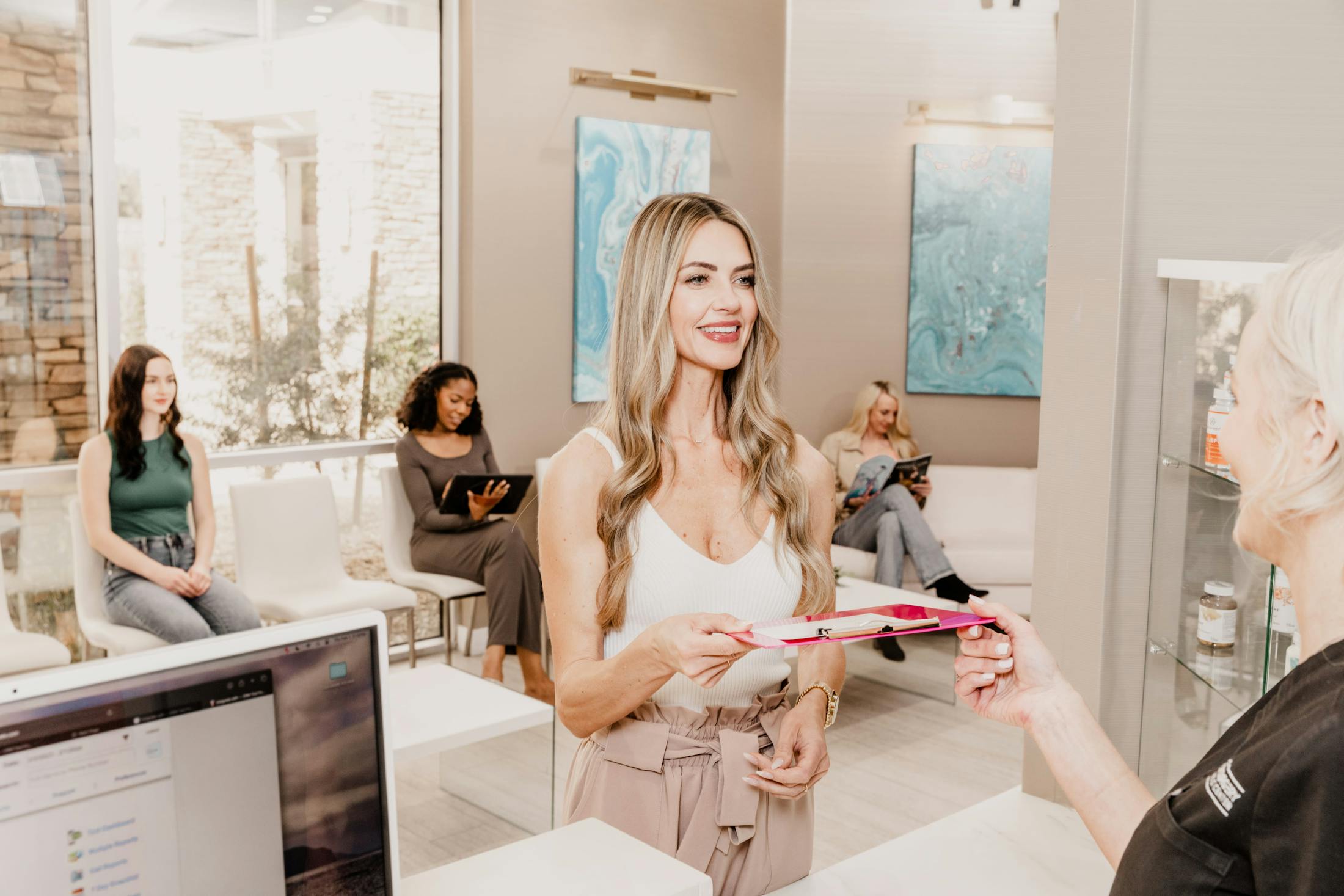 woman handing a clipboard to a receptionist