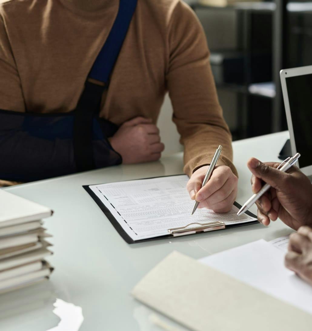 man with arm in sling filling out forms