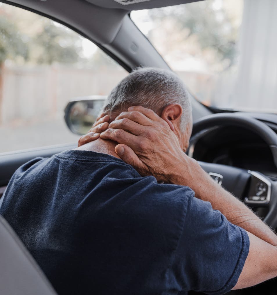 man holding neck in car