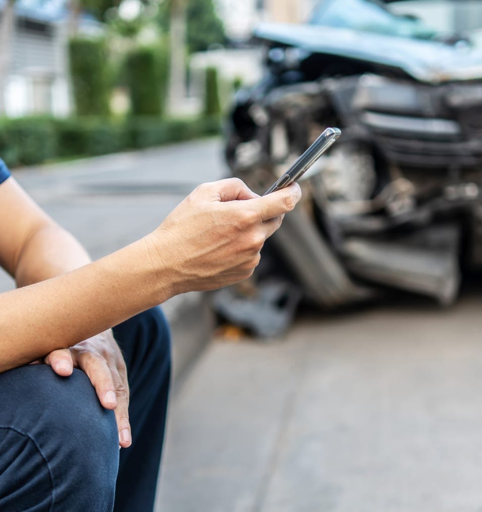 man on phone next to wreck