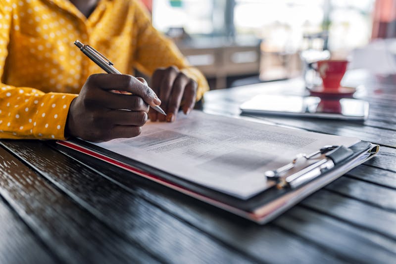 close-up of woman signing papers