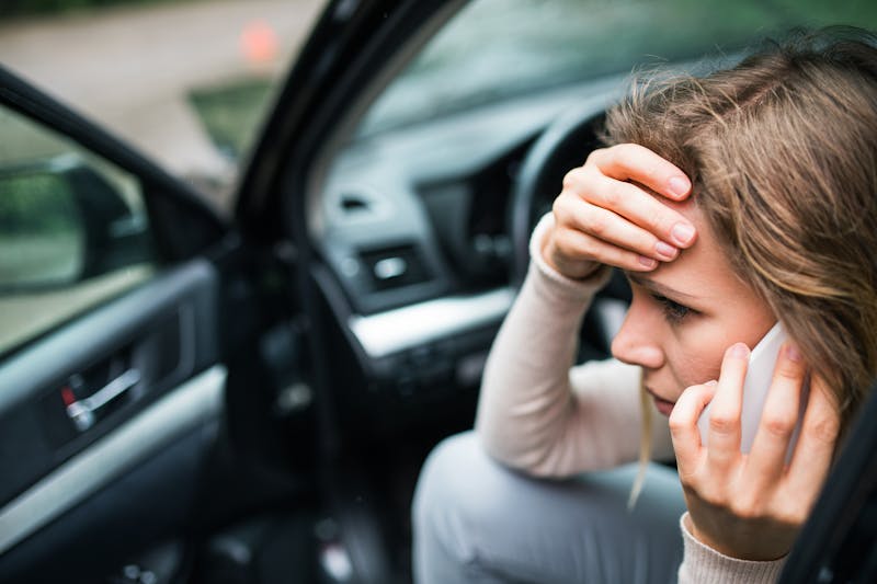A woman making a call in a car