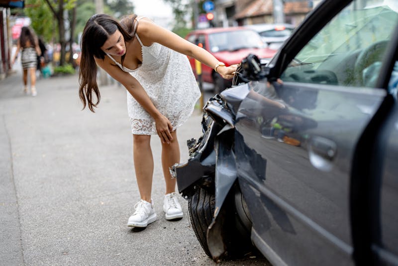 Woman looking at crashed car