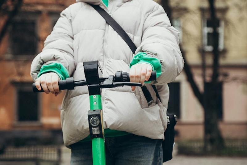 A young girl riding an e-scooter