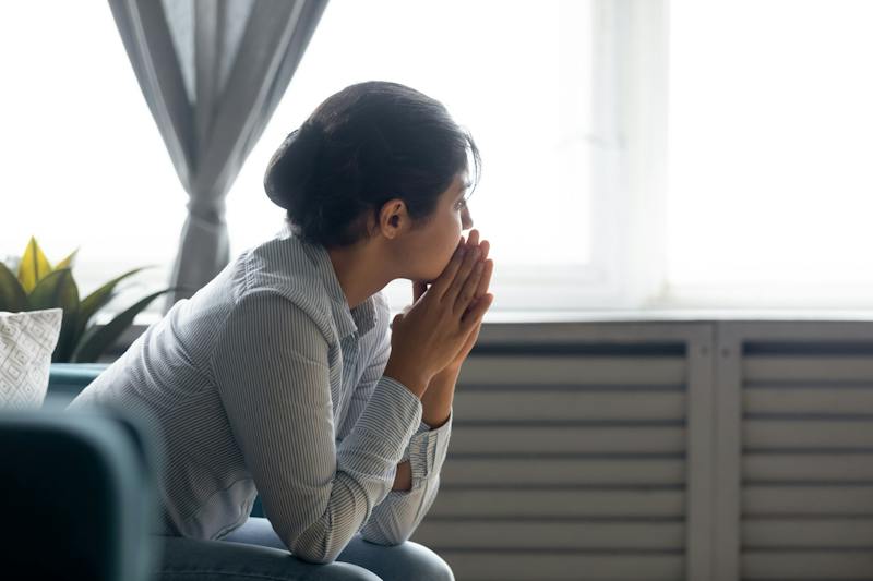 Woman sitting on a couch and thinking deeply