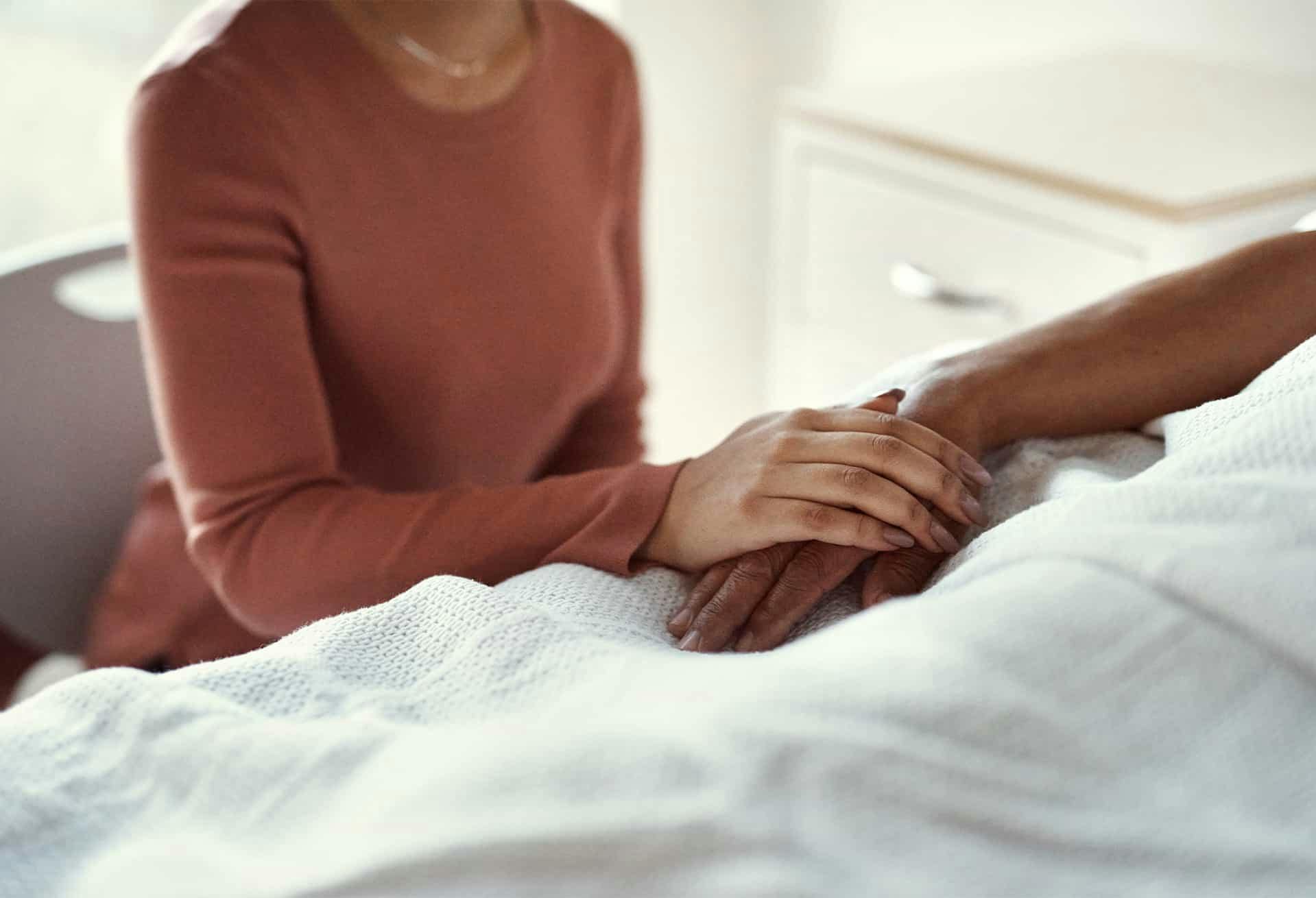Person holding hands with patient in hospital