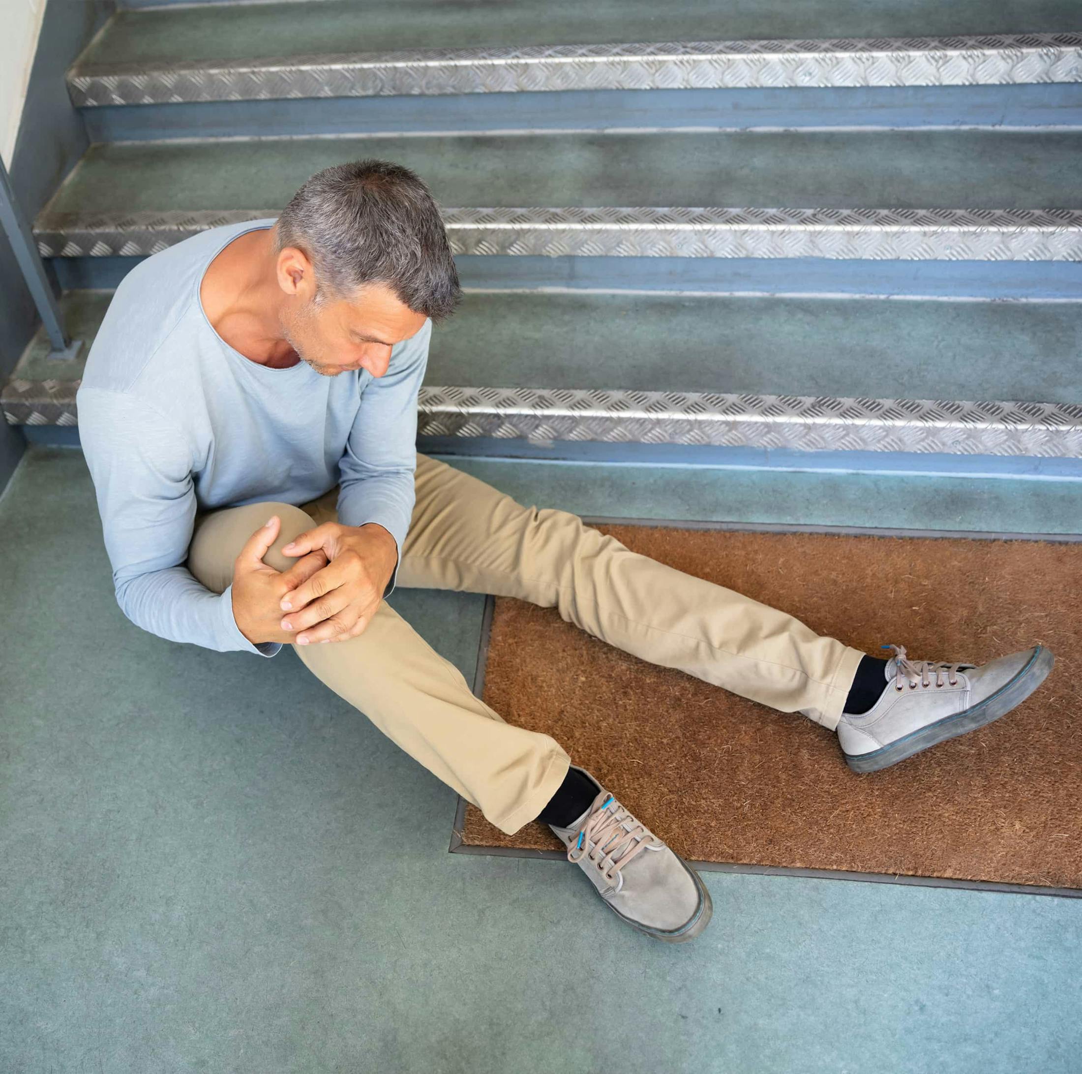 Man sitting on the floor holding knee