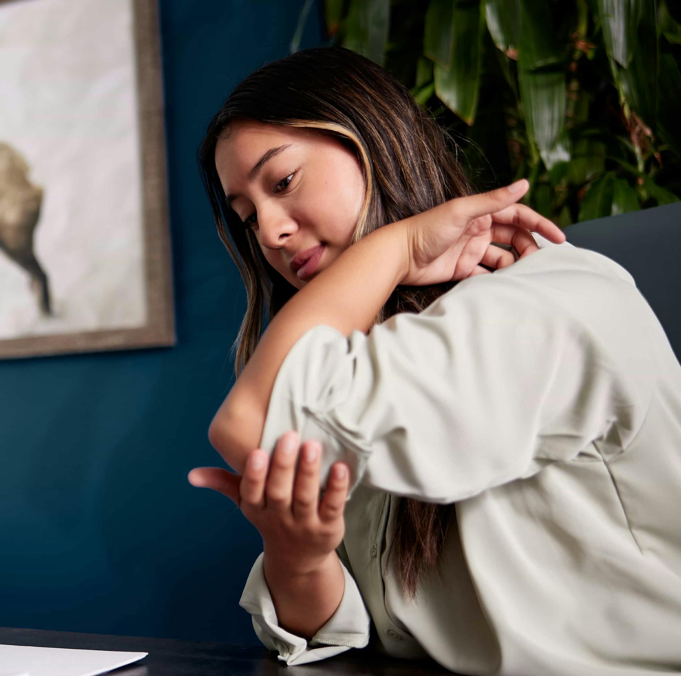 Woman holding her elbow