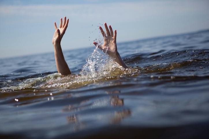 A person's hands above the water