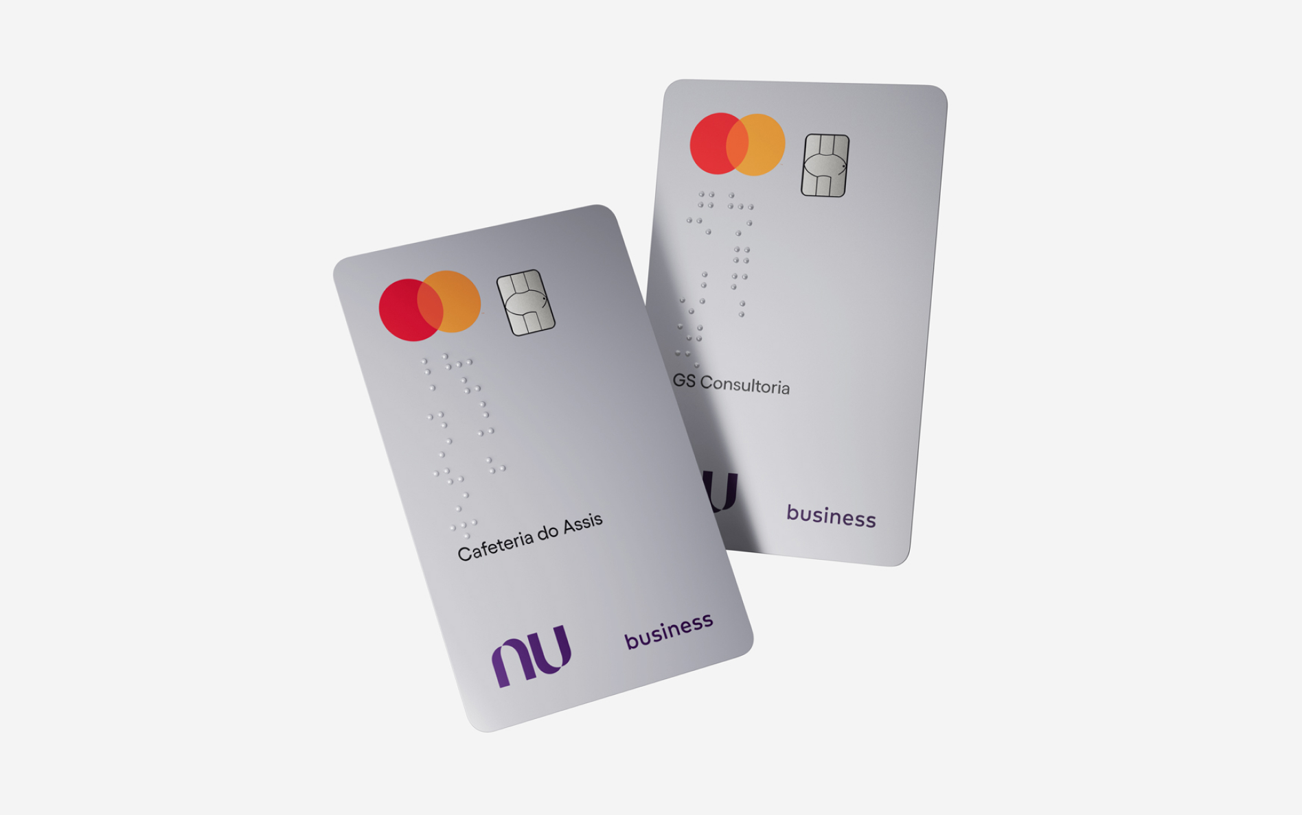 Dois cartões Nubank PJ sobrepostos e flutuando na tela. Eles têm o nome da empresa escrito em braille.