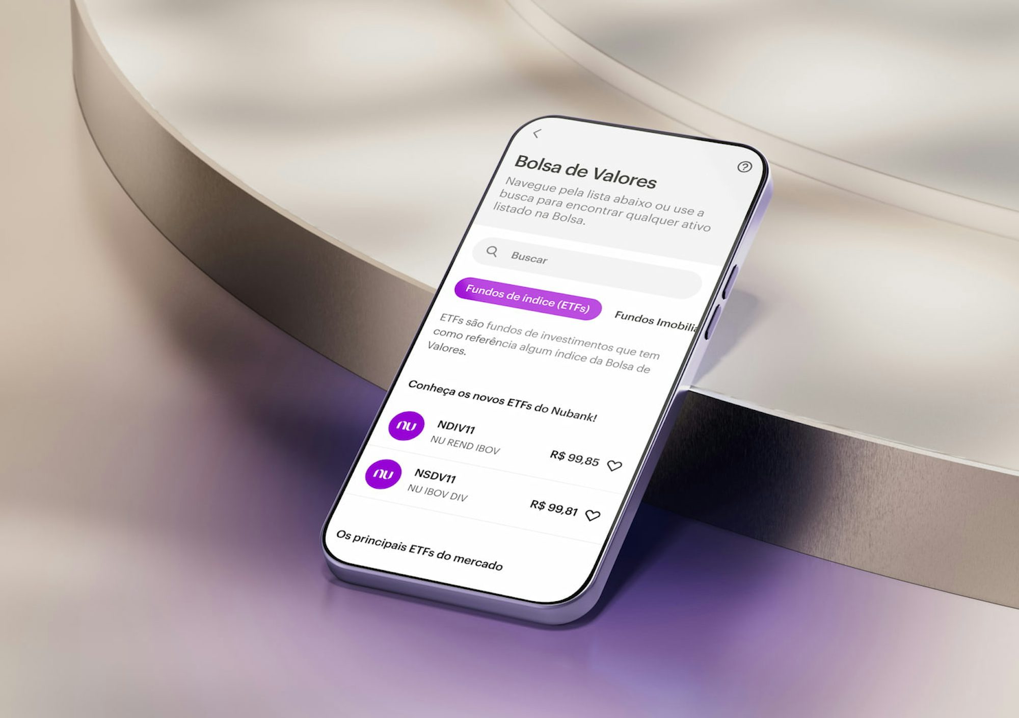 A tela de um celular apoiado em uma forma geométrica em tons claros. Na tela, o aplicativo do Nubank na área de Bolsa de Valores.