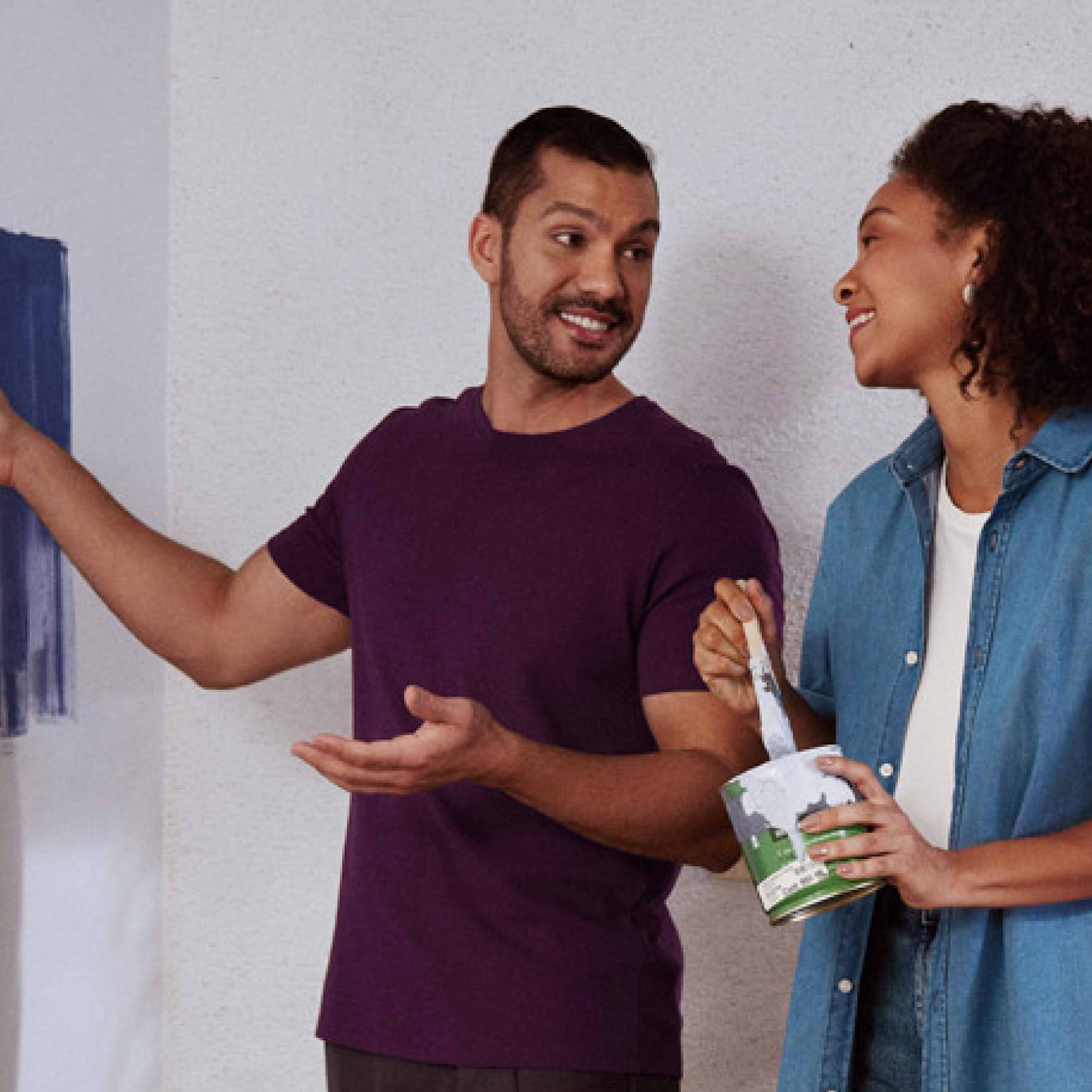 Casal testando tintas na parede