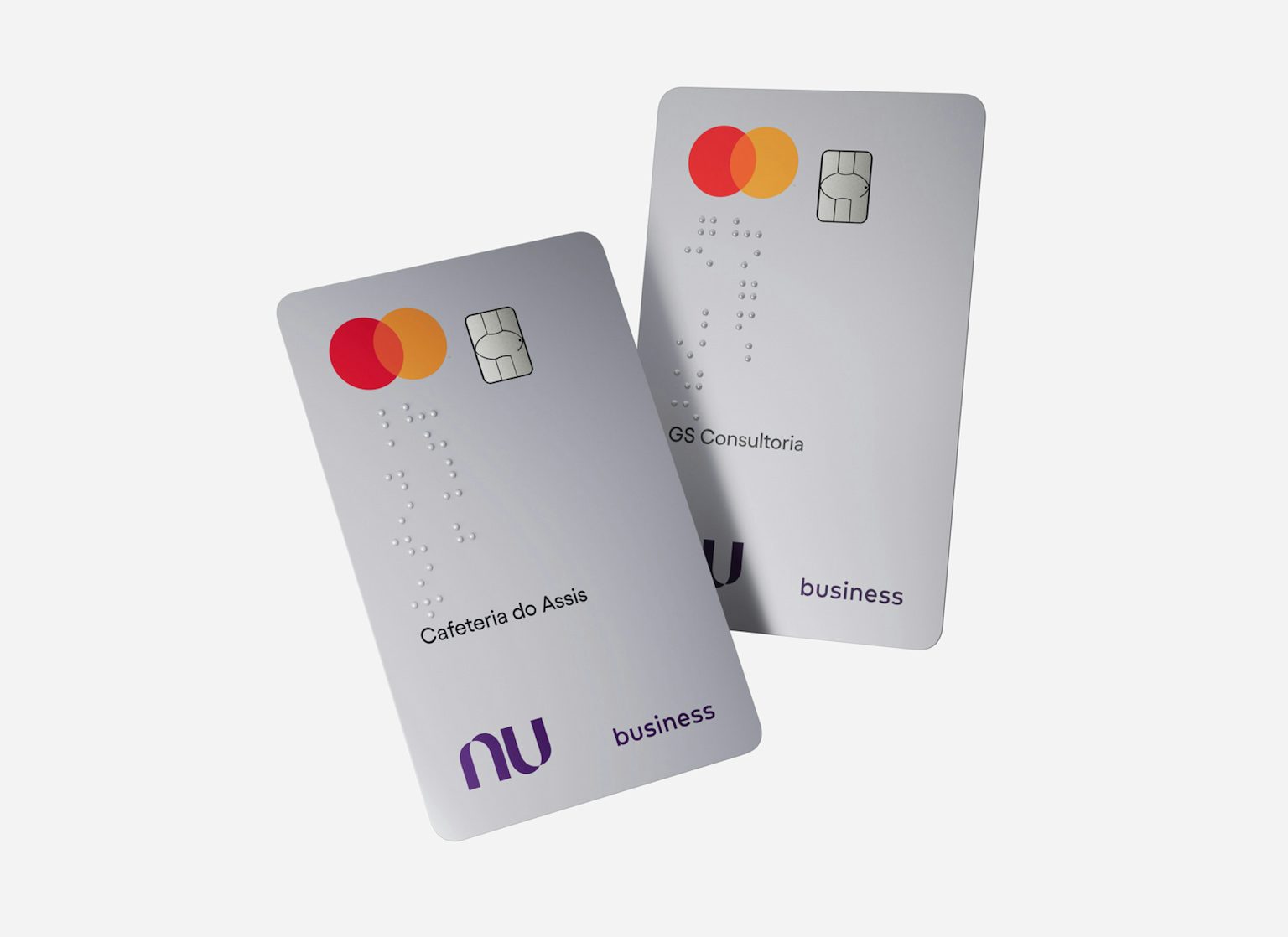 Dois cartões Nubank PJ sobrepostos e flutuando na tela. Eles têm o nome da empresa escrito em braille.