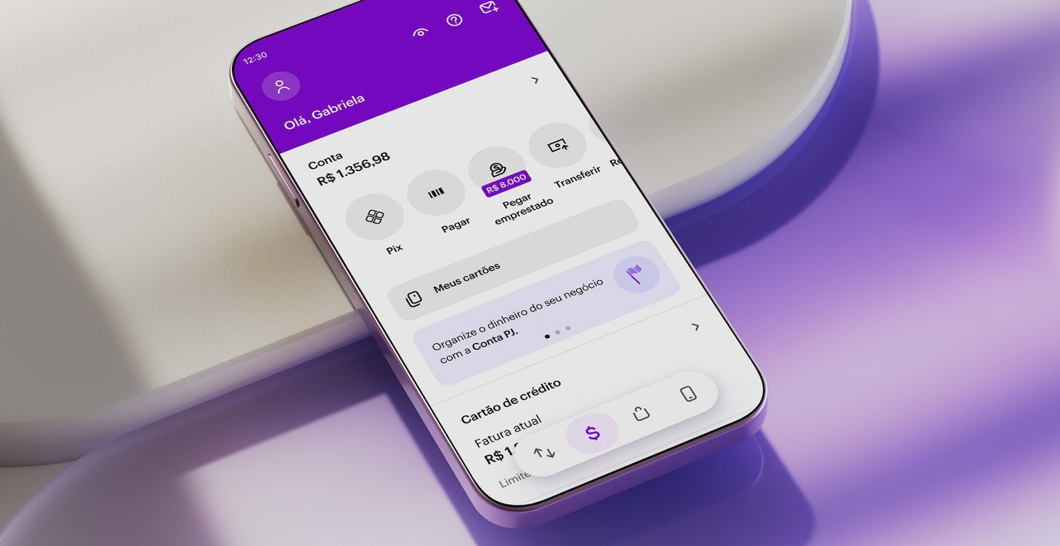 Celular apoiado em uma forma geométrica branca com aplicativo Nubank aberto na tela inicial.