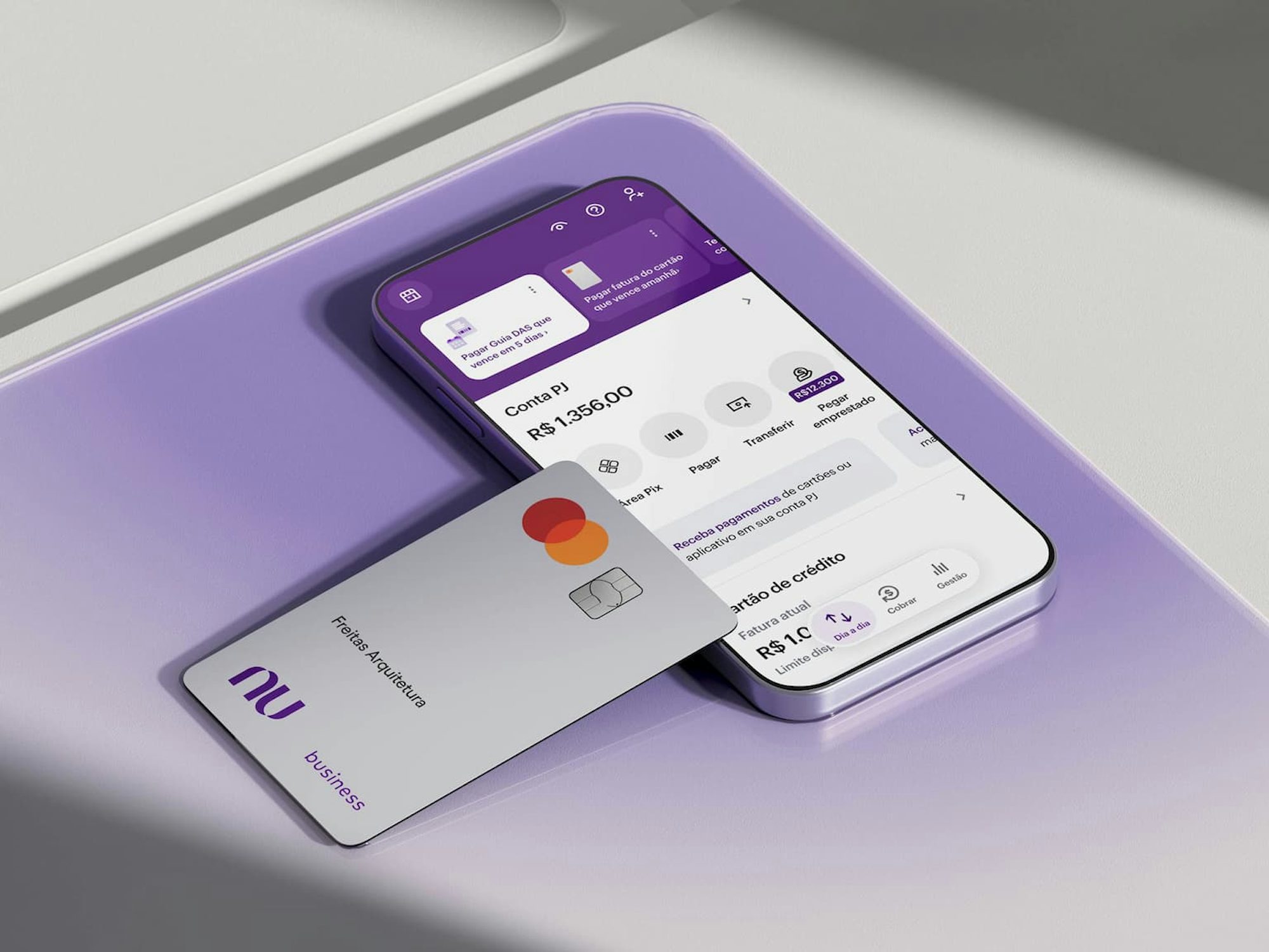 Celular apoiado em uma forma geométrica branca com aplicativo Nubank aberto na área de Conta PJ mostrando as opções.