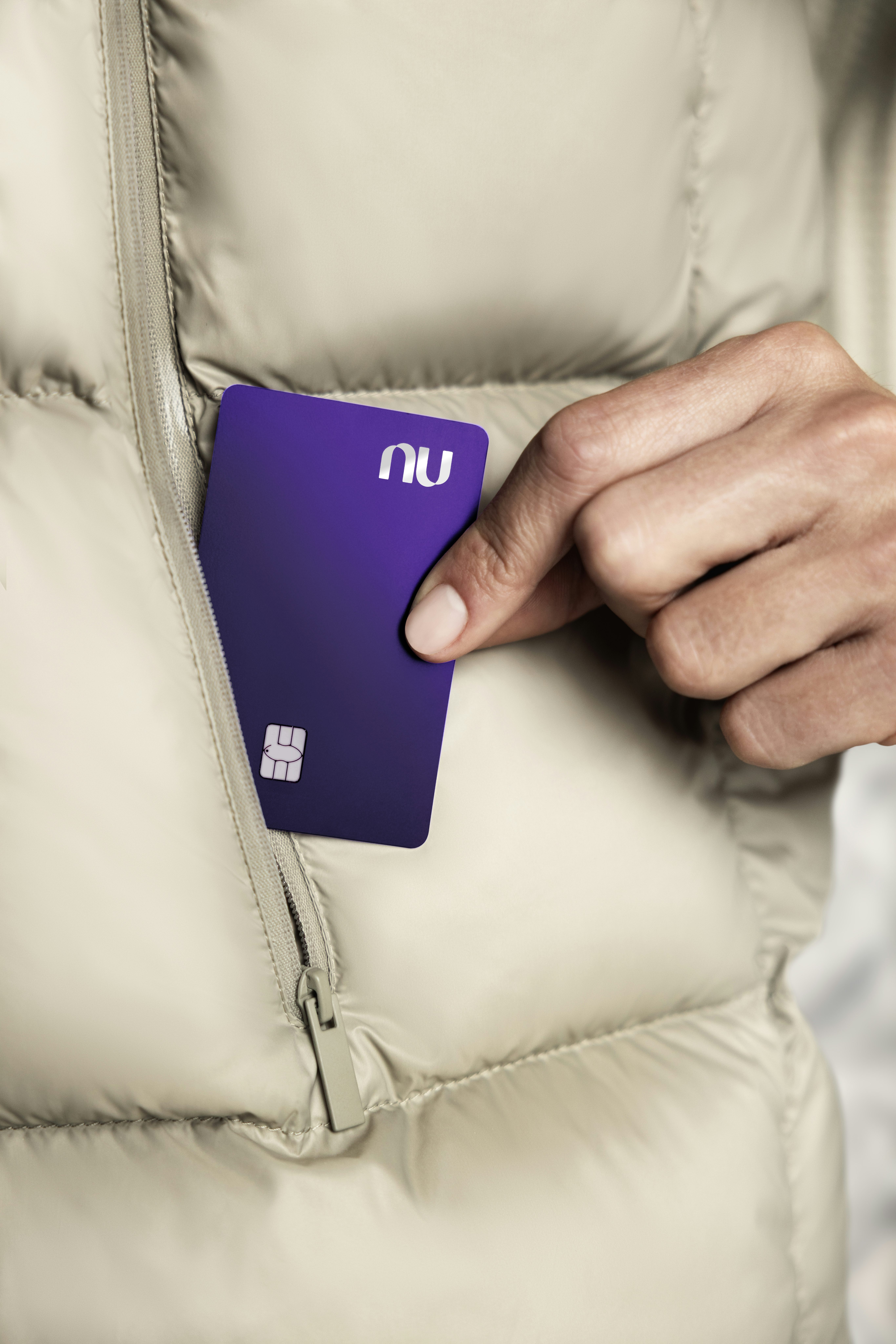 Uma pessoa retirando um cartão Ultravioleta do bolso de sua jaqueta.