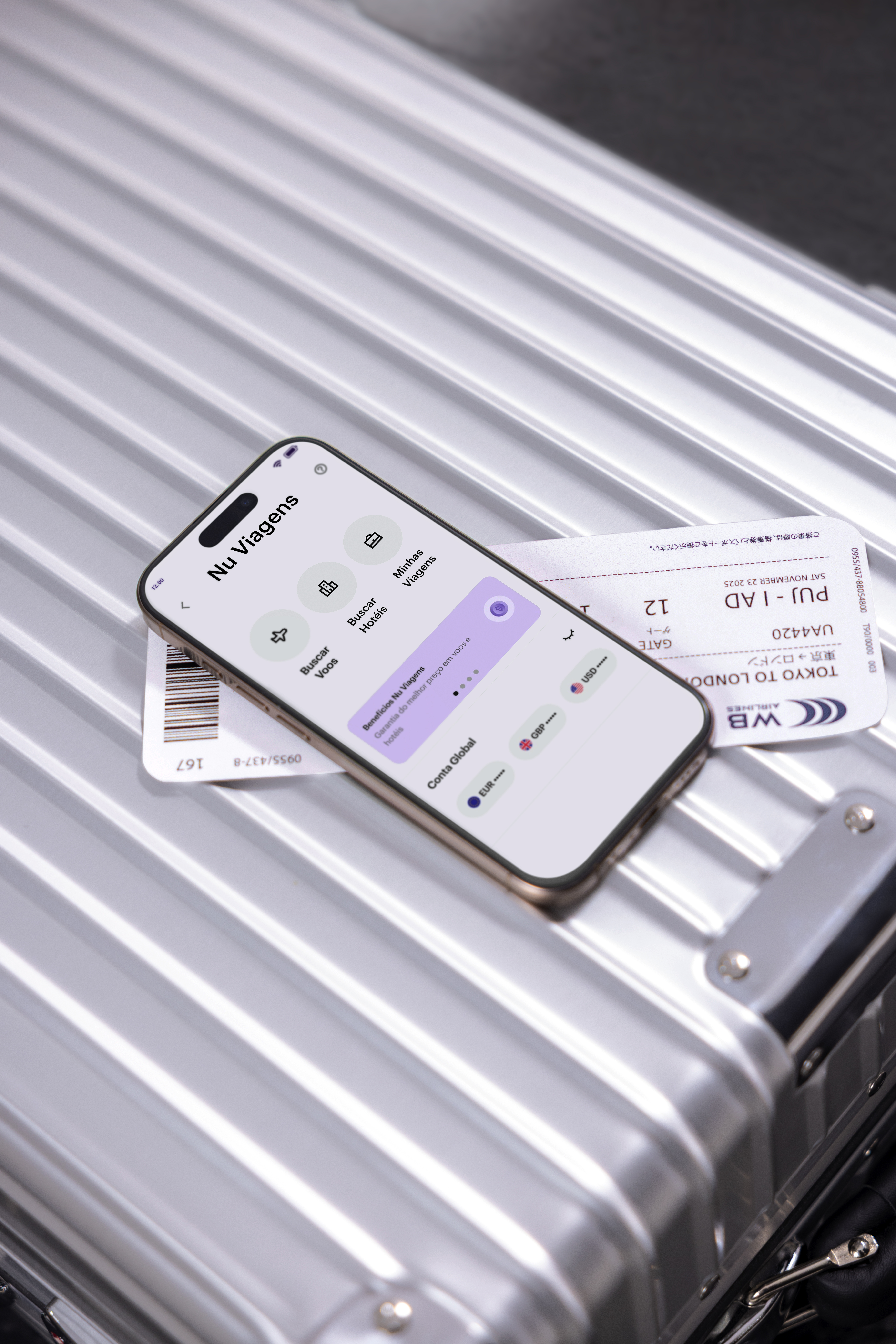 Celular com o aplicativo do Nubank aberto na sessão do Nu Viagens, o celular está ao lado de uma passagem aérea internacional, em cima de uma mala de viagem