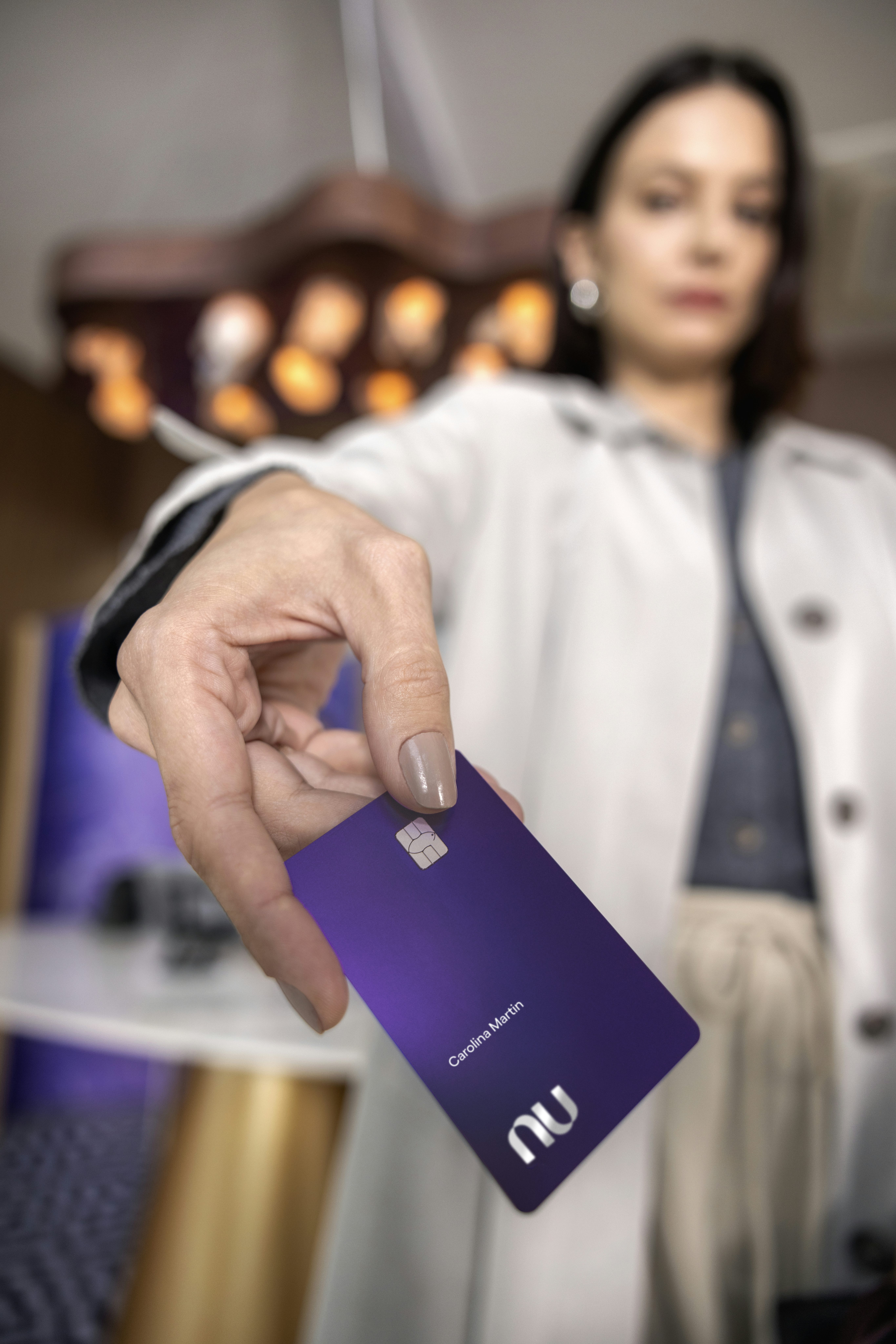 Mulher branca na entrada em uma sala vip estendendo um cartão Ultravioleta