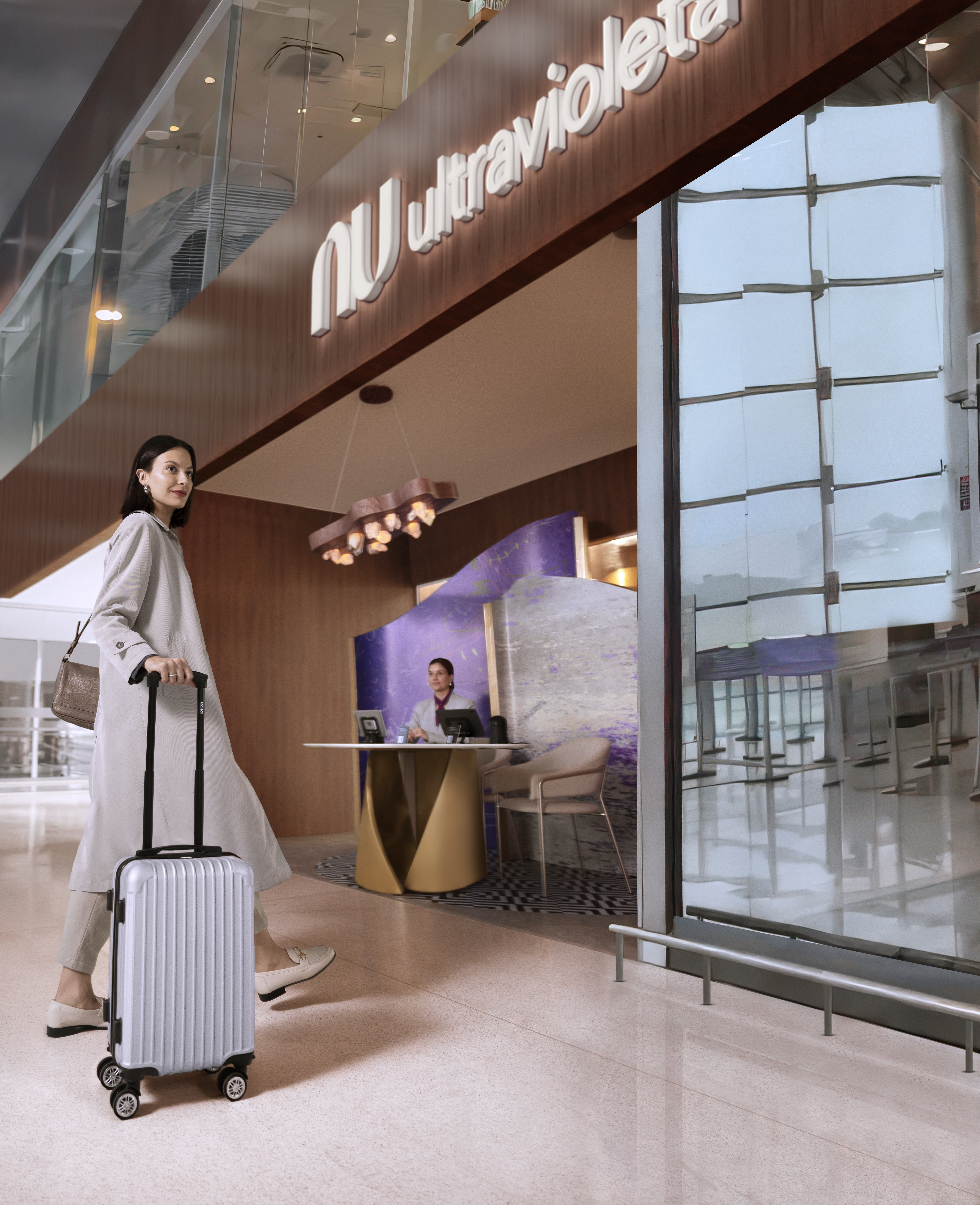 Mulher branca acompanhada de sua mala cinza entrando no Ultravioleta Lounge no aeroporto de Guarulhos