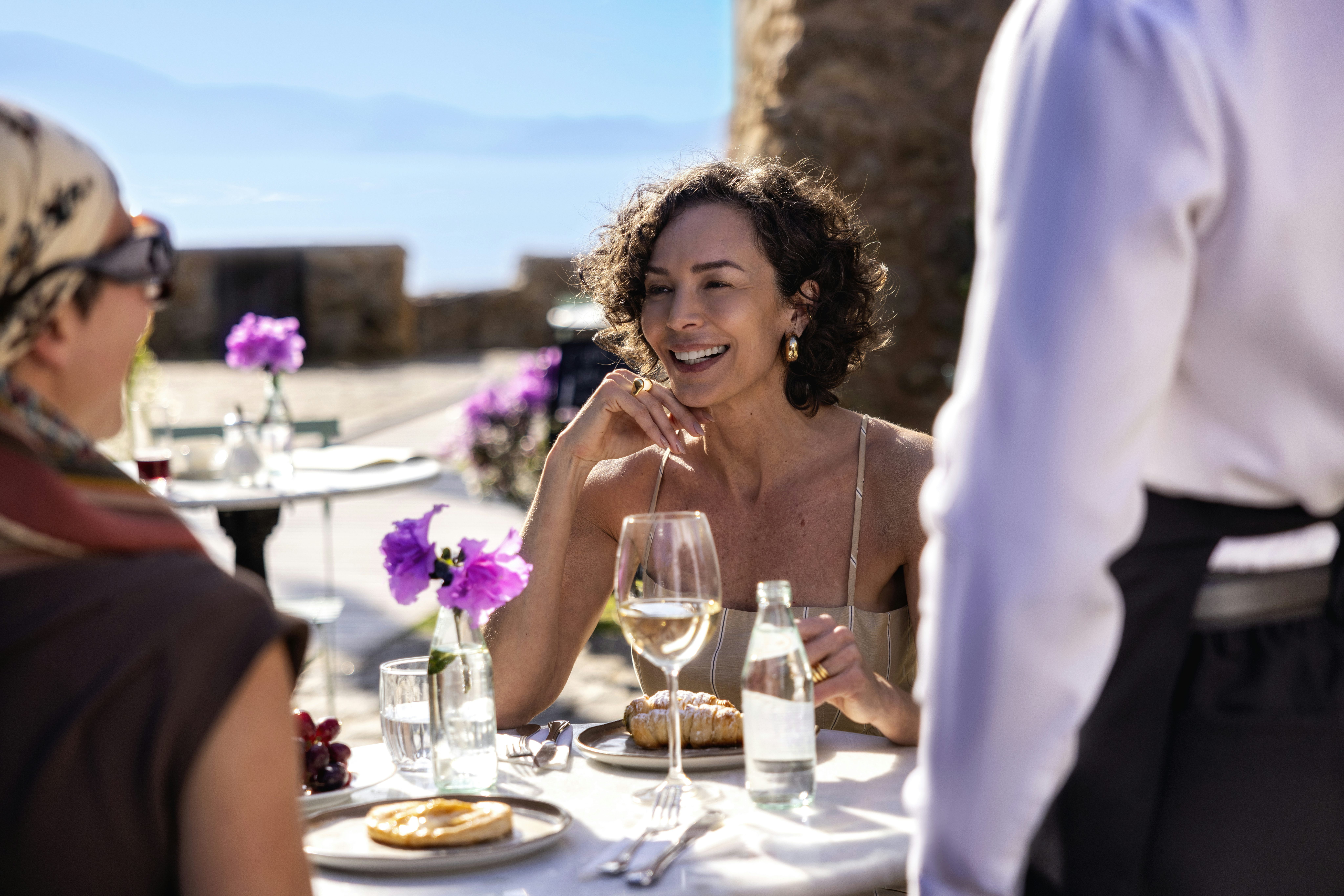 Mulher de cabelos curtos curtindo um almoço e vinho na Itália