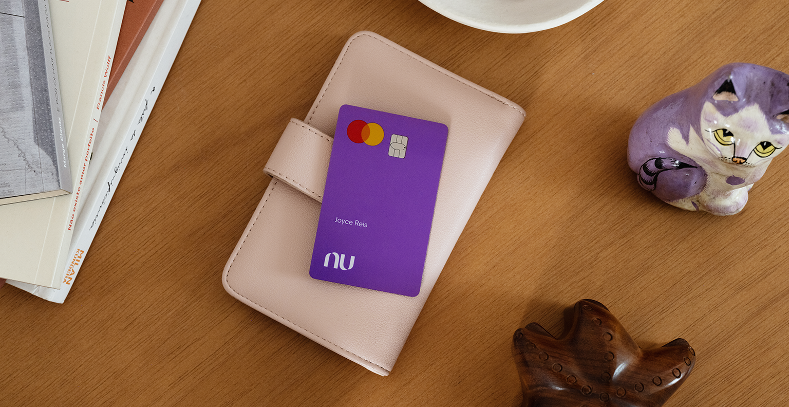 Cartão de crédito Nubank apoiado em uma carteira em cima de uma mesa