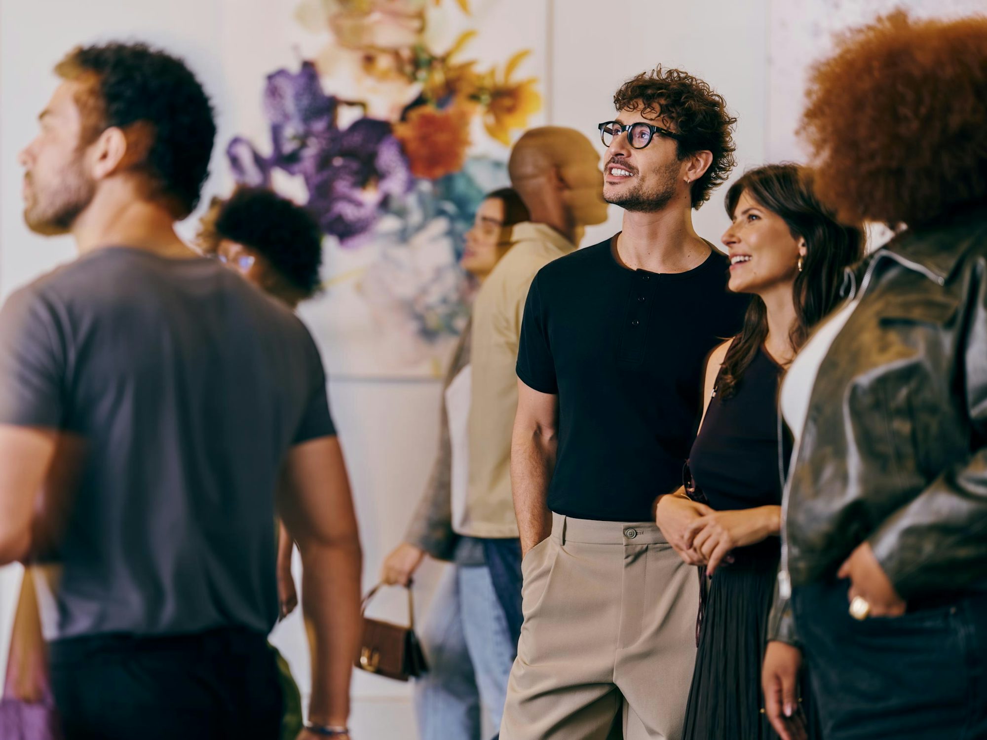 Pessoas observando obras de arte em uma exposição.