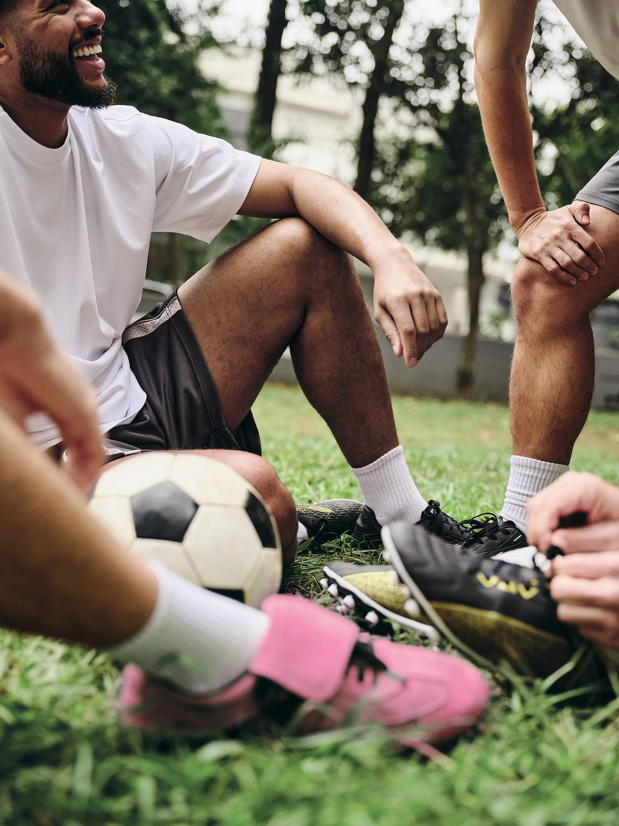 Amigos sorrindo enquanto jogam ou assistem futebol