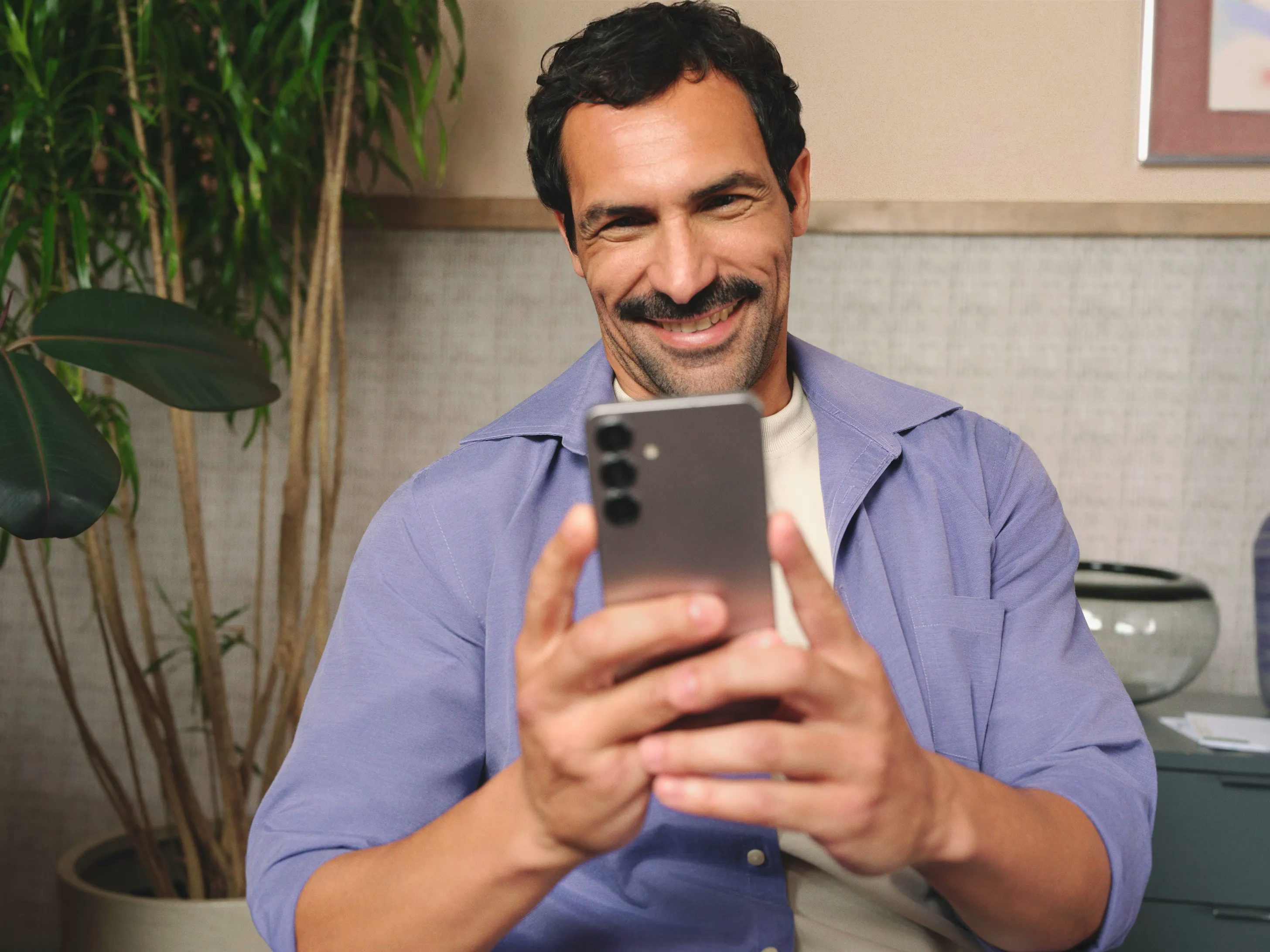 Homem olhando para o celular e sorrindo