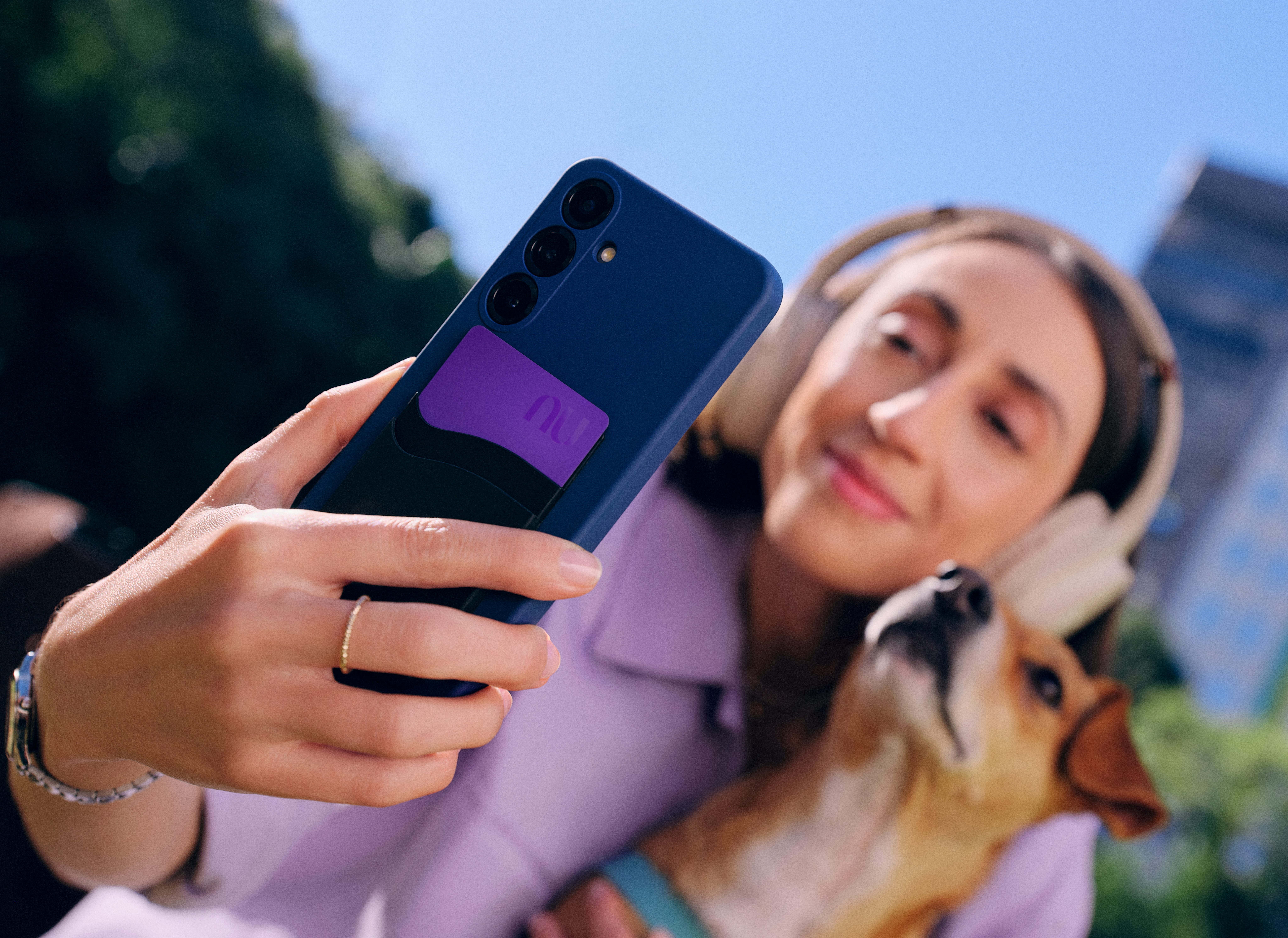 Mulher fazendo self com o celular abraçada em um cachorro caramelo