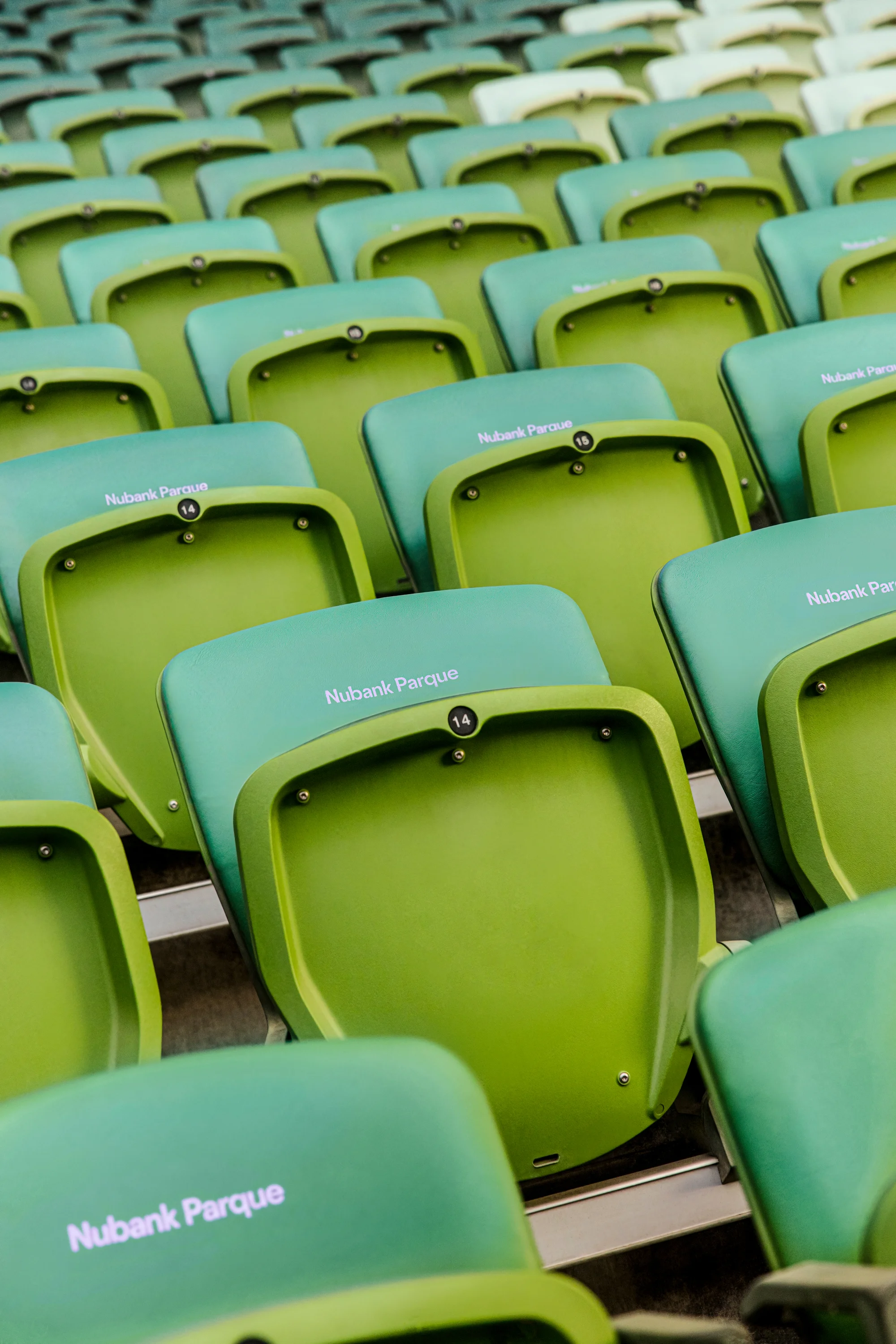 Poltronas verdes com encosto escrito Nubank Parque