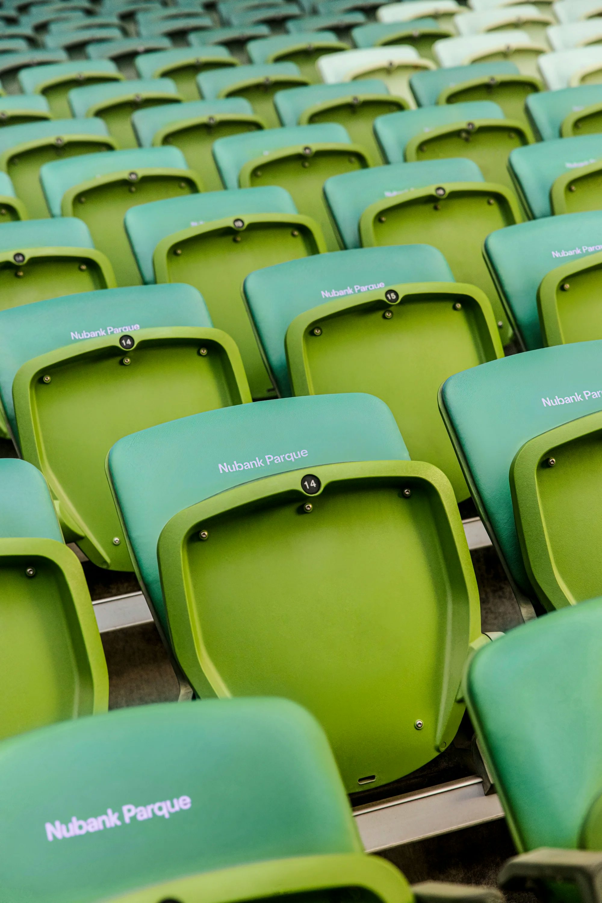 Poltronas verdes com encosto escrito Nubank Parque