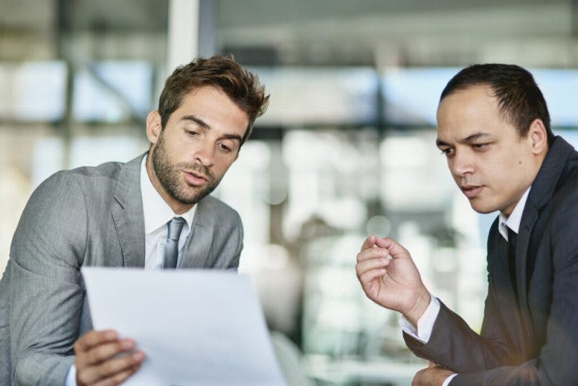 Shot of two colleagues looking over paperwork together in an office