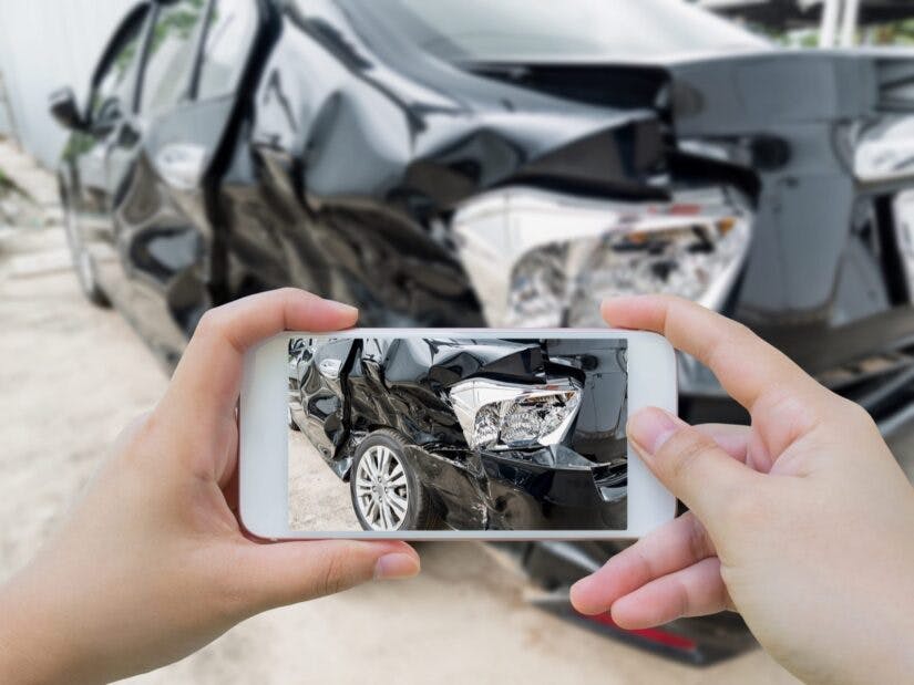 Man taking photo of a crashed car