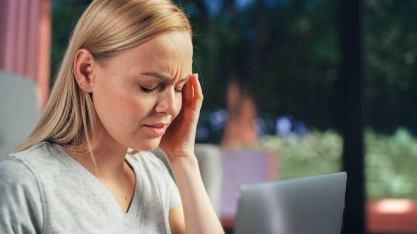 A Woman Holding Her Head In Pain