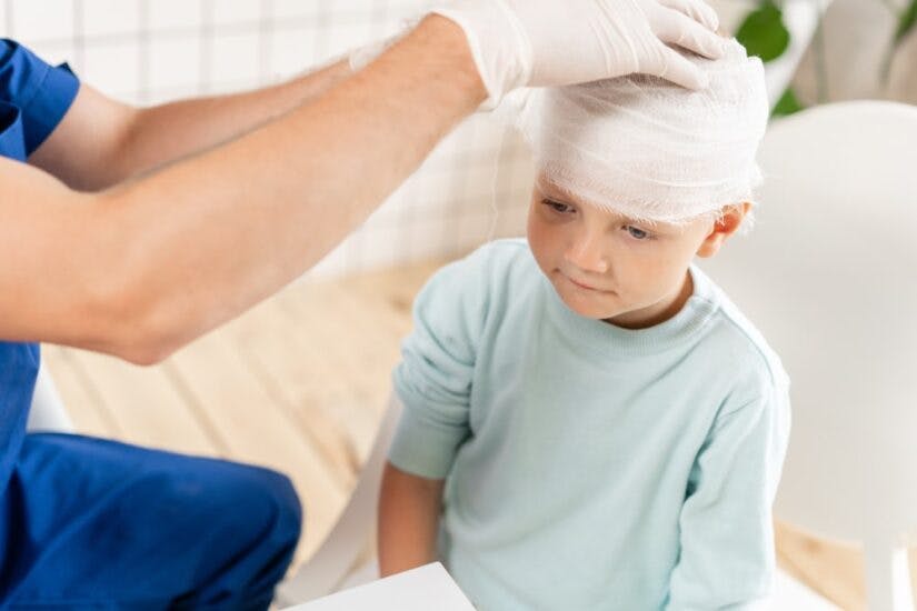 A Child Getting His Head Bandaged By A Doctor