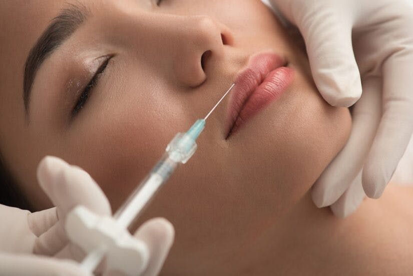 Doctor Making A Lip Filament Injection On A Woman