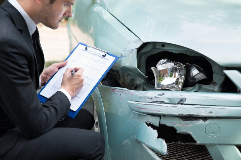 Photo of an Insurance Agent Examining a Car 
