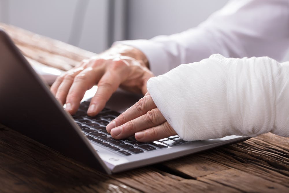 Hand Injured Person Using Laptop