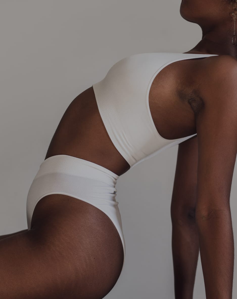 Black woman leaning back, with white underwear