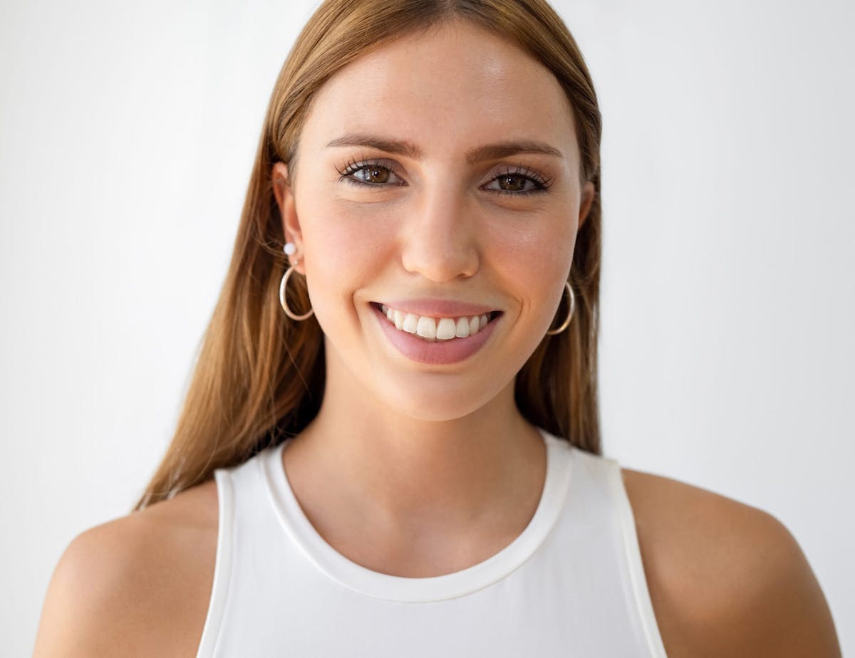 woman with redish hair in white tank top