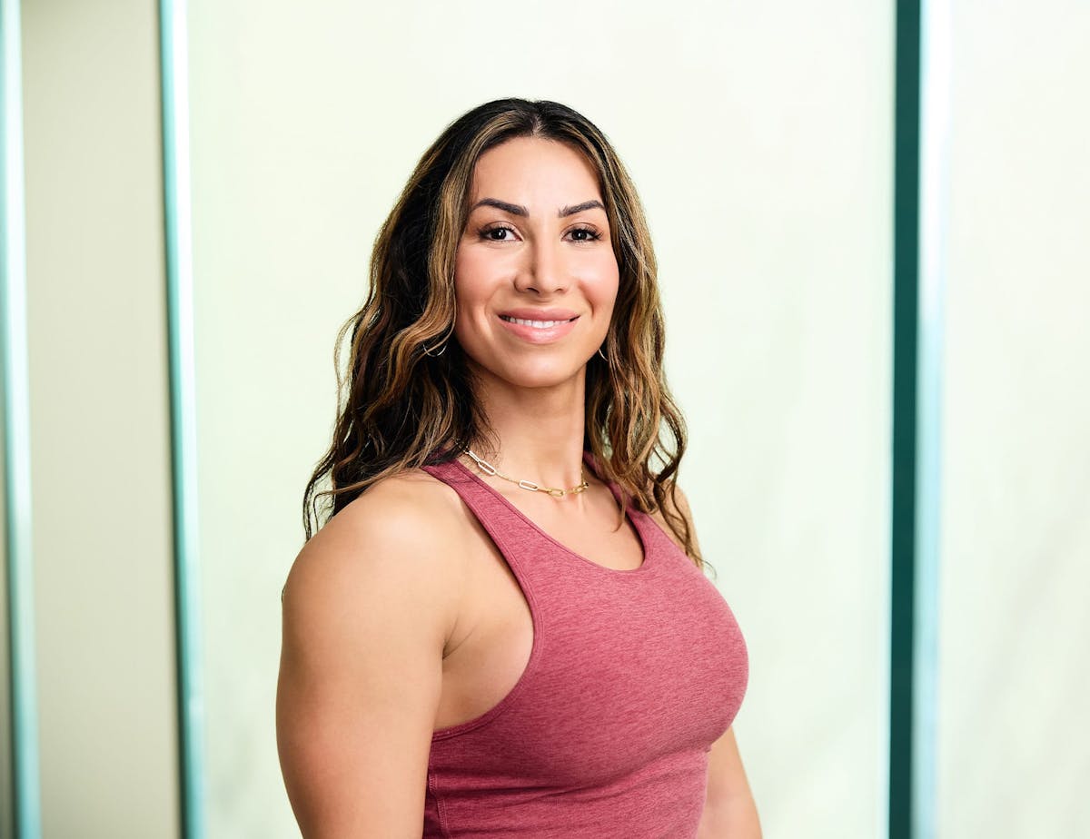 woman in red tanktop smiling and looking forward