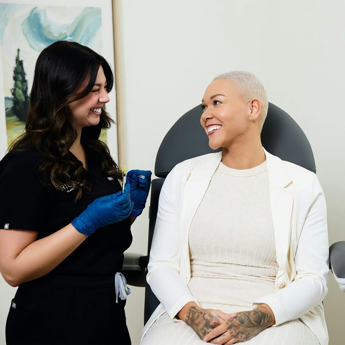 nurse with patient smiling together while patient is sitting