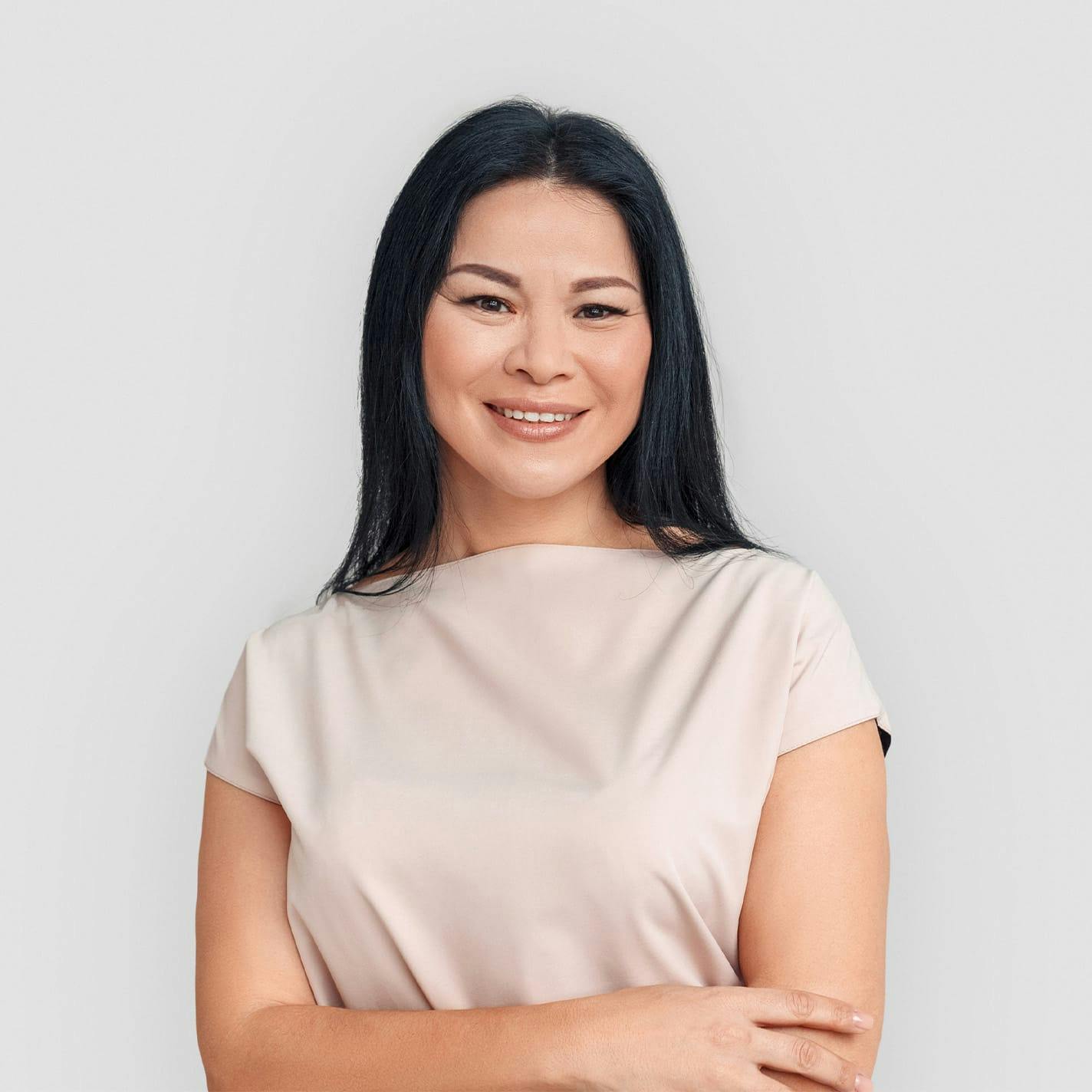 woman with black hair in beige shirt