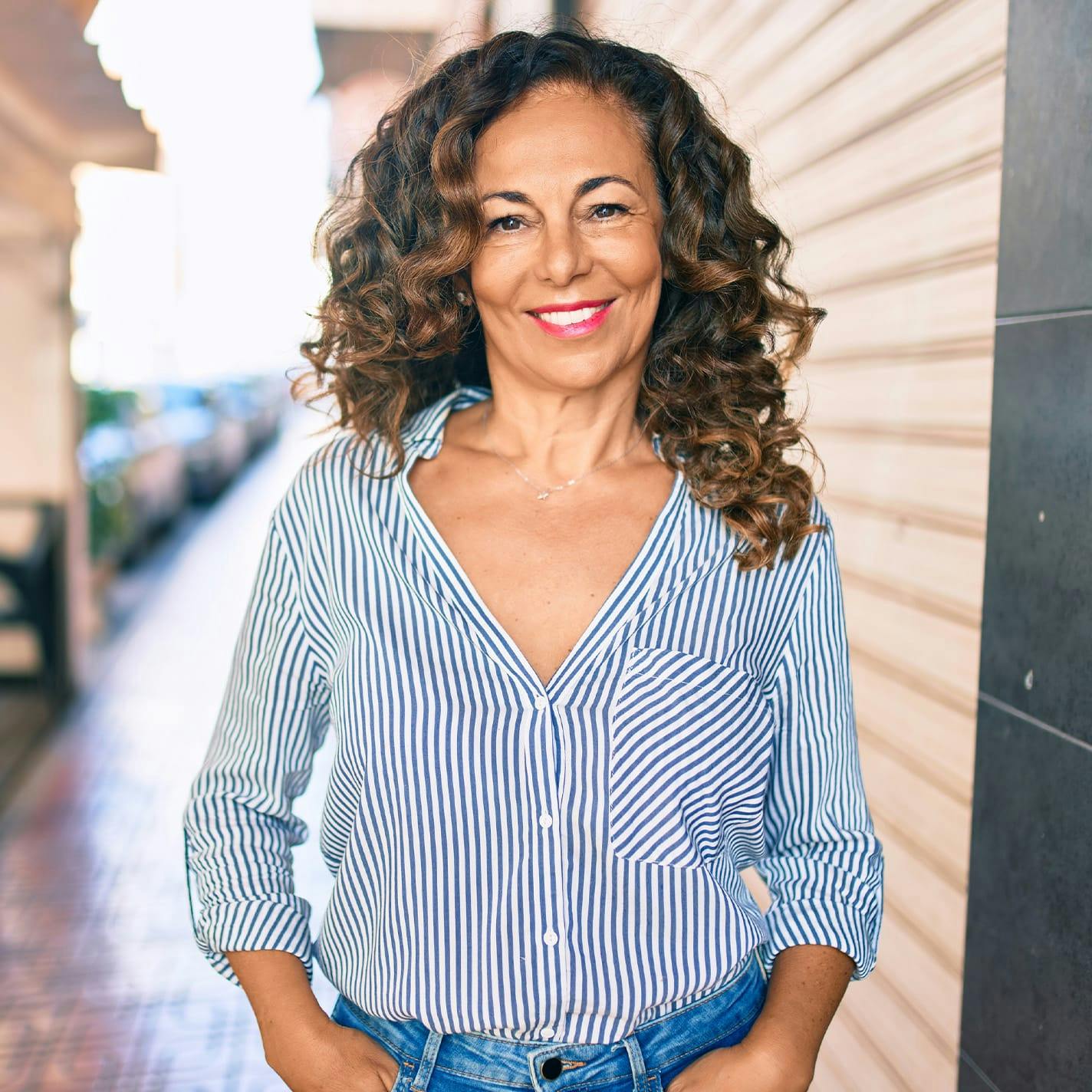 woman in blue flowy shirt with brown curly hair