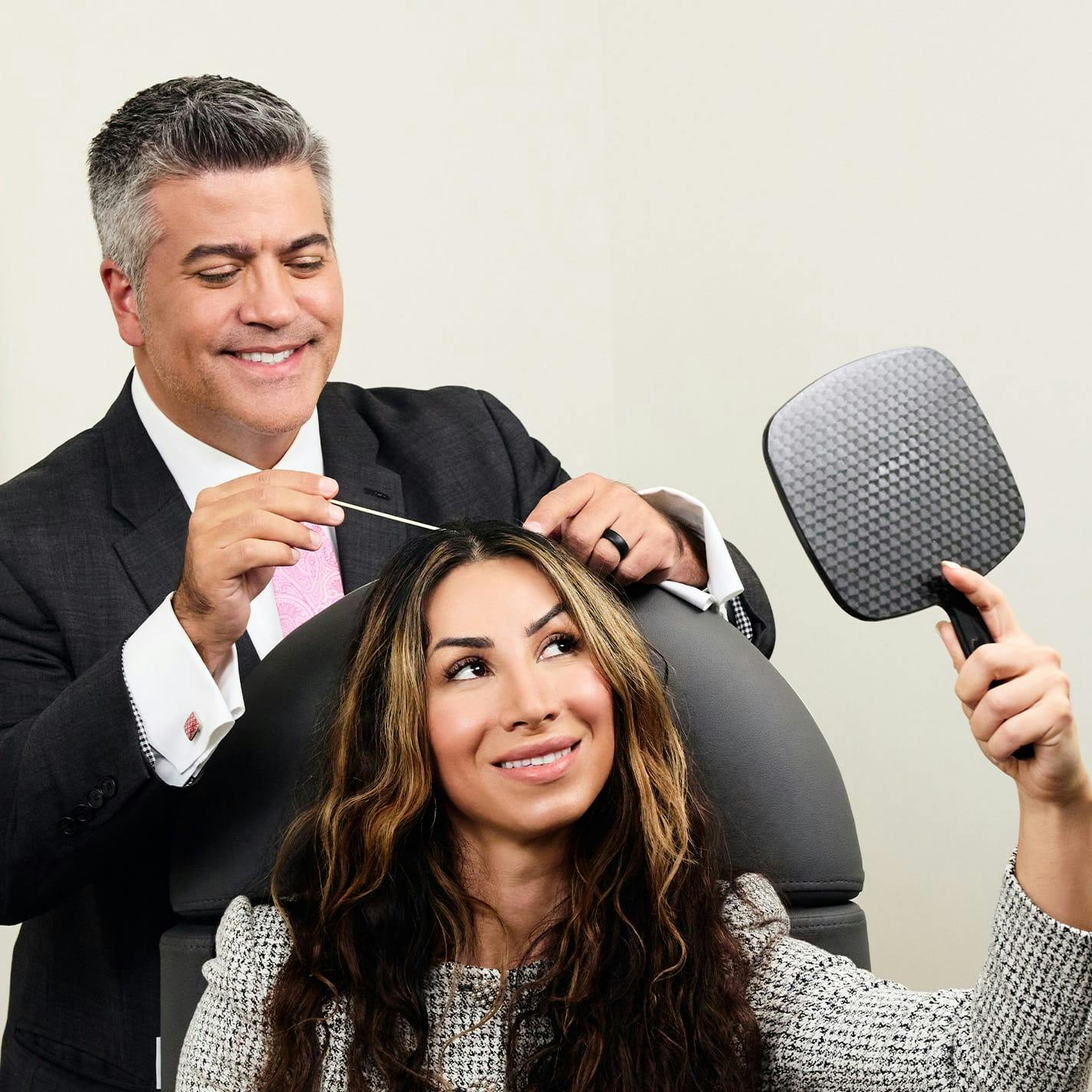 Dr. Higdon pointing to patient's scalp while patient looks in mirror to see
