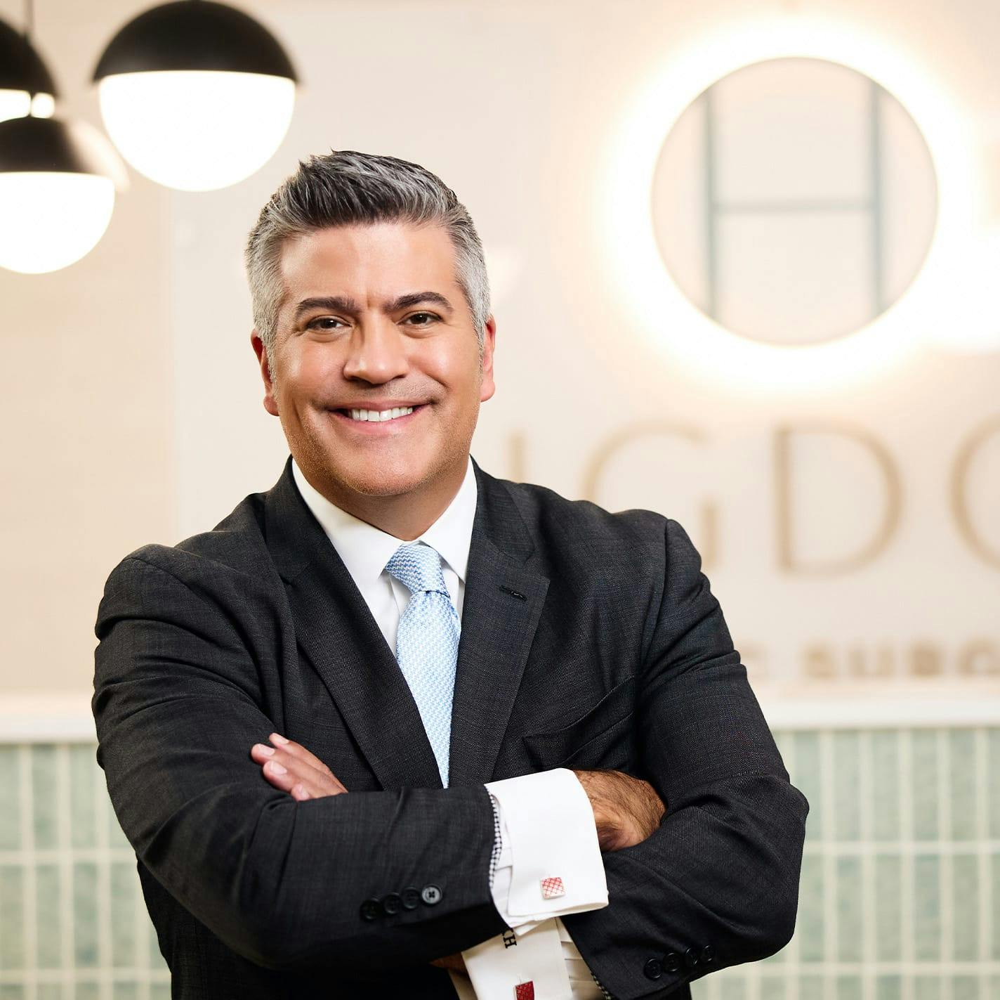 Dr. Higdon with his arms crossed in front of Higdon Plastic Surgery sign